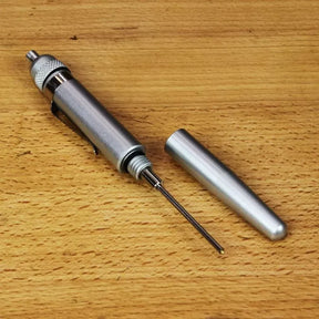Metal mechanical center punch tool with cap on wood surface, woodworking marking tool