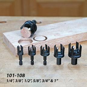 Six plug cutters in various sizes with wood plugs and drilled board on a woodworking bench