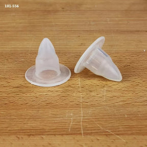 Clear plastic bench dogs for woodworking on a wooden surface, close-up view