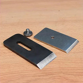 Woodworking plane replacement blades and screw on a wooden surface