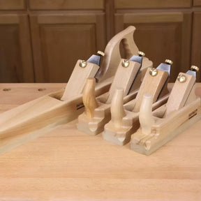 Set of four wooden hand planes on a workbench for woodworking and carpentry tasks