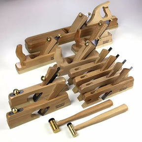 Woodworking hand plane set and mallets with brass and wood handles on white background