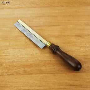 Small dovetail saw with brass back and wooden handle on a wood surface, woodworking tool