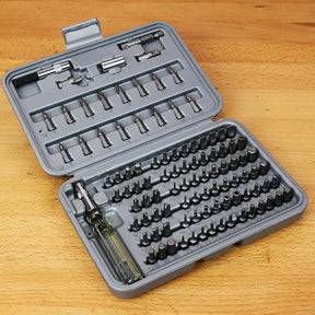 Precision screwdriver bit set in gray case on wooden workbench