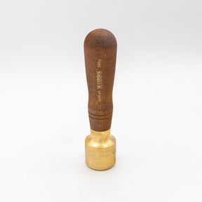 Brass woodworking mallet with a wooden handle on a white background