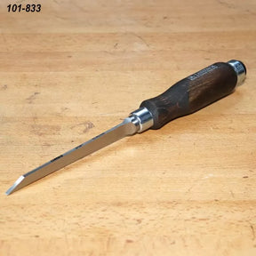 Bench chisel with beveled blade and wooden handle on a woodworking table