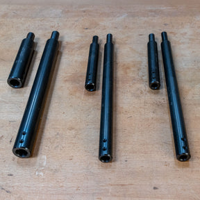 Three-piece set of black steel woodworking jig rods on a workbench