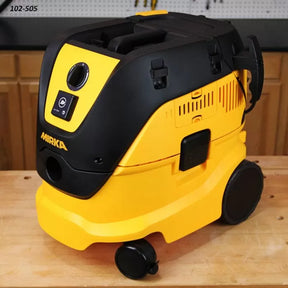 Yellow and black dust extractor vacuum for woodworking on a workshop table.