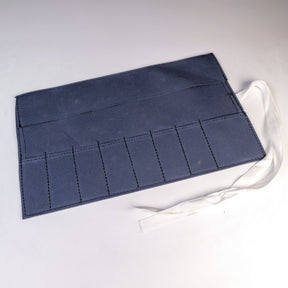 Seven-pocket canvas tool roll with white tie straps on a white background.