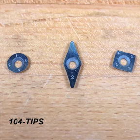 Three replaceable carbide cutter tips in round, diamond, and square shapes on a wood surface