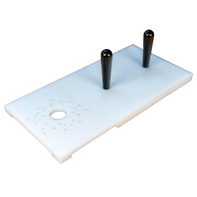 Woodworking jig with two black handles and alignment holes on a white rectangular plate