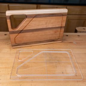 Clear acrylic cutting board template on workbench beside finished wooden cutting board