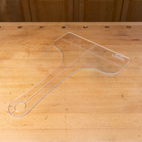 Clear acrylic cutting board template on wooden workbench for woodworking projects