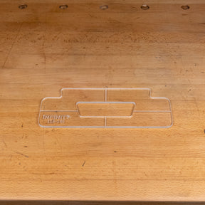 Clear acrylic handle template for woodworking, shown on a wooden workbench