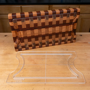 Clear acrylic cutting board template with curved sides on a wood workbench, patterned wood board behind
