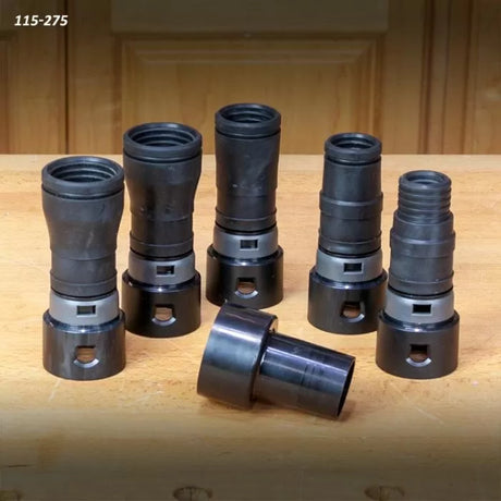 Set of six black plastic dust collection hose adapters for woodworking tools on a wooden surface