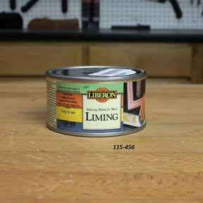 Liberon liming special effects wax can on a woodworking bench in a workshop setting
