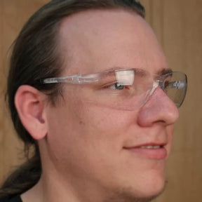Person wearing clear safety glasses, wood background, protective eyewear for woodworking