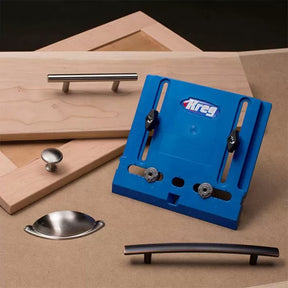 Kreg cabinet hardware jig with assorted cabinet handles and wooden drawer fronts on a work surface