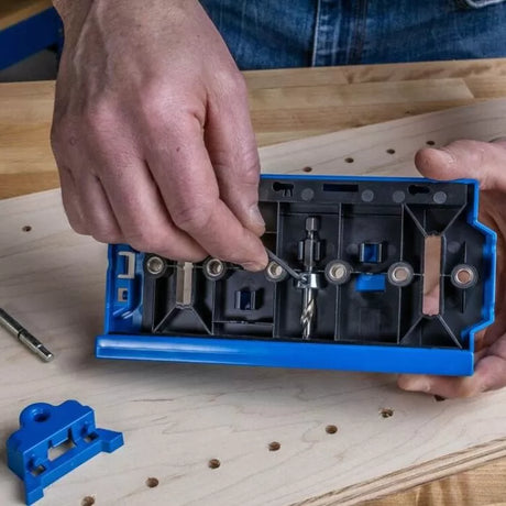 Person adjusting pocket hole jig kit on woodworking bench with drill bit and accessories