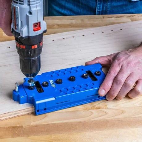 Drilling pocket holes in wood with a pocket hole jig and cordless drill on a workbench