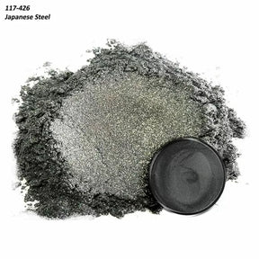 Fine Japanese steel powder with metallic texture and round black container on white background.