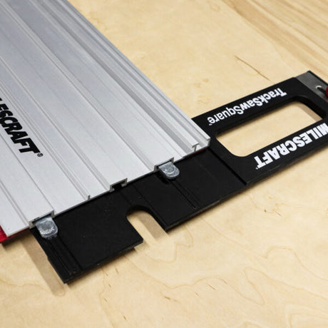 Milescraft track saw square accessory aligned on a wooden work surface for precise cutting