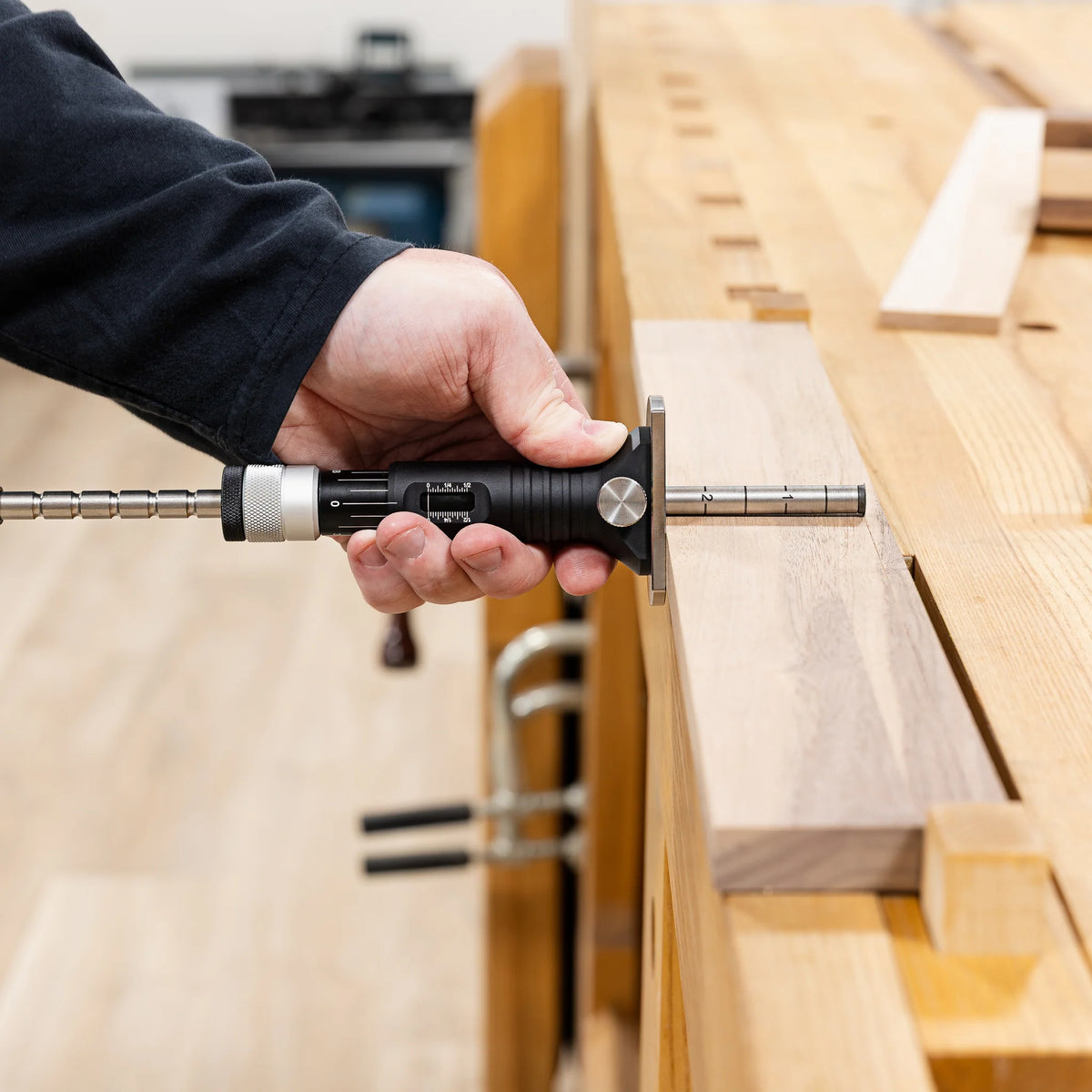 Woodworker using the JessEm Wood Sabre II marking gauge on a workpiece at the bench