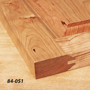 Close-up of wooden cabinet door with joinery detail on light wood surface, model 84-051.