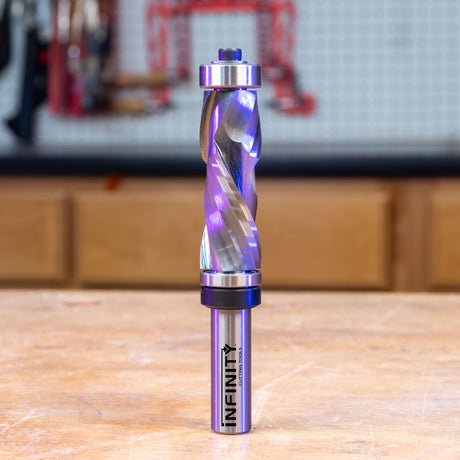 Solid carbide compression double bearing router bit on a workbench in a woodworking shop.