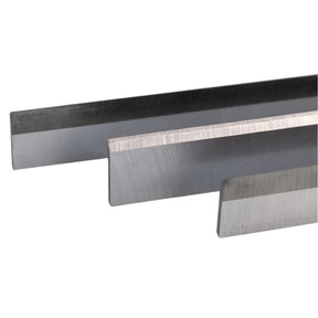Three precision steel planer blades for woodworking tools, close-up view