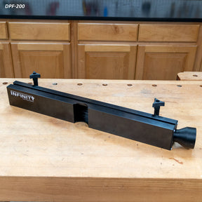 Router table dust collection fence on woodworking bench with mounting knobs, black finish
