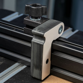Aluminum router table fence stop block attached to a T-track woodworking fence