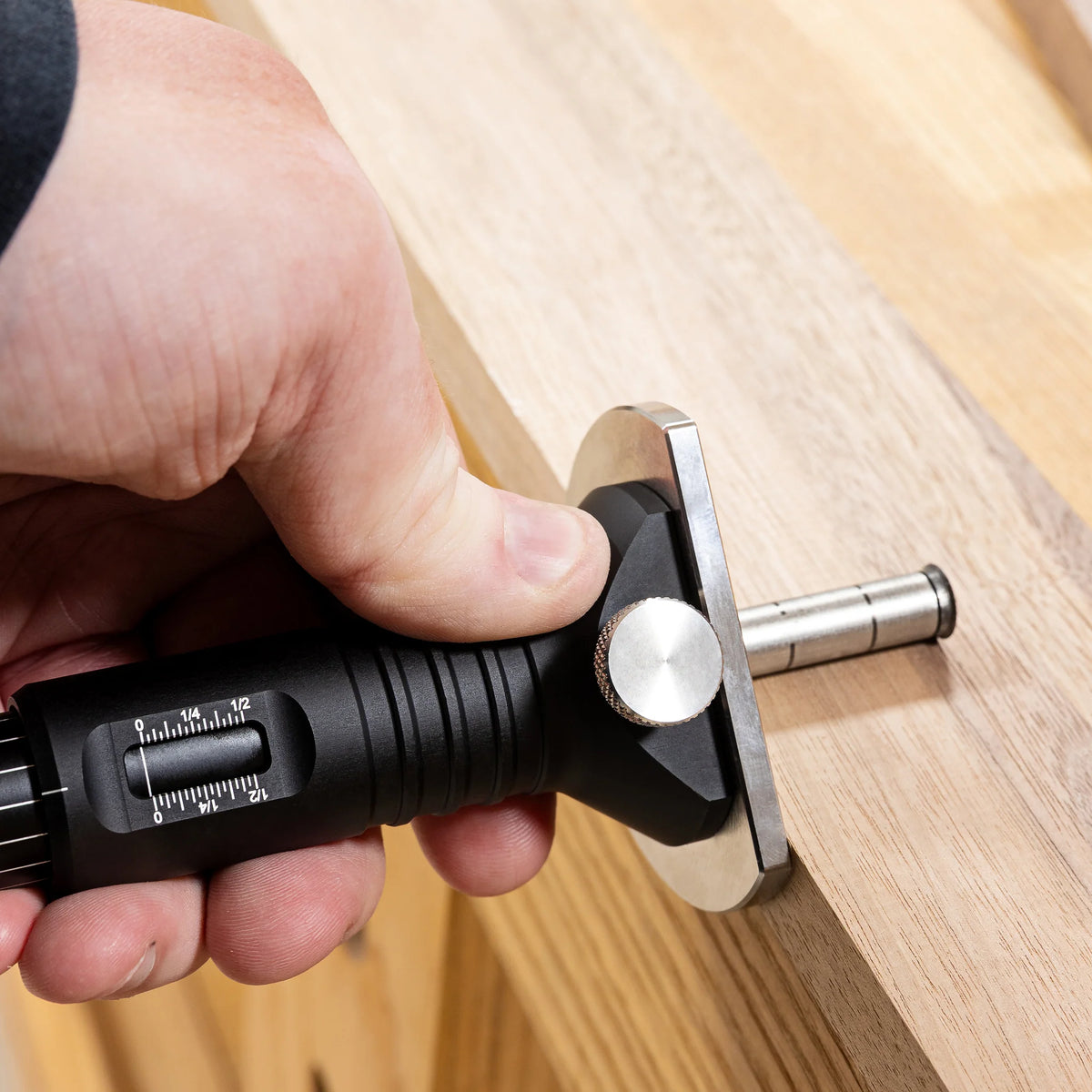 Close-up of a hand scribing a line along a board edge with the JessEm Wood Sabre II marking gauge