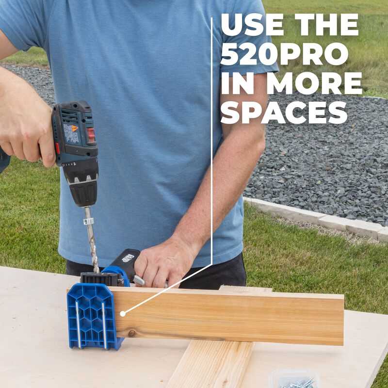 Hand holding a Kreg Pocket Hole drill guide on a wooden surface.