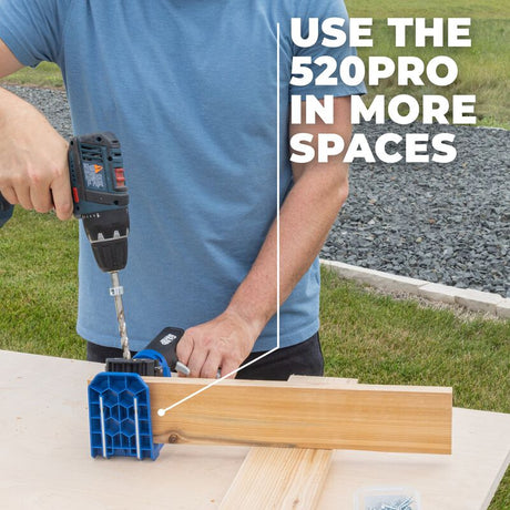Hand holding a Kreg Pocket Hole drill guide on a wooden surface.