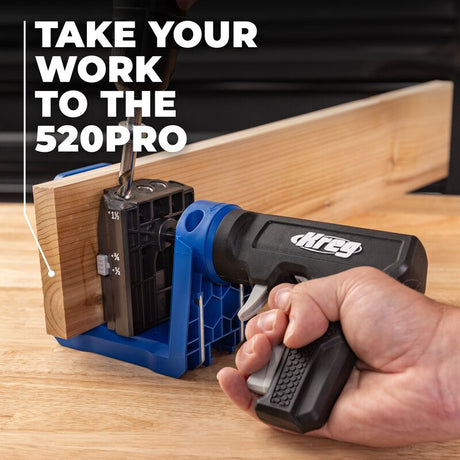 Hand holding a Kreg Pocket Hole drill guide on a wooden surface.