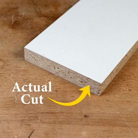 Close-up of clean saw blade cut on laminated particle board, showing smooth woodworking finish.