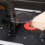 Router table with a router bit and wood piece on a workshop table.