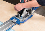 Person using a circular saw with a guide rail on a wooden surface