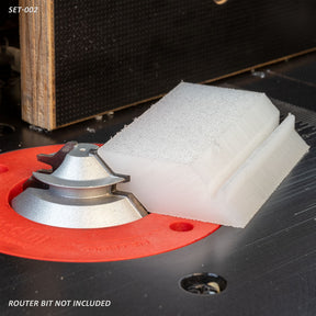Router table setup with a large router bit and a white profile template, woodworking tool accessory
