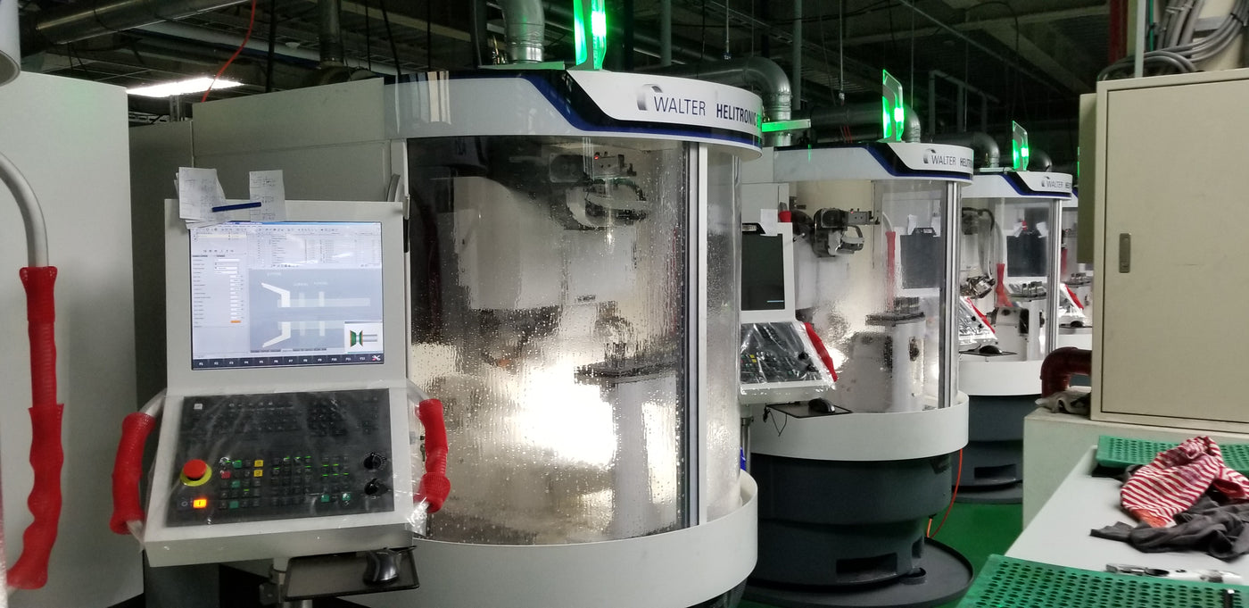 CNC machine in a factory setting with control panel and digital display.