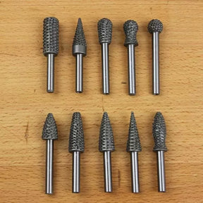 Ten rotary burrs for woodworking or metal shaping on a wooden surface, various shapes and sizes