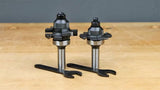 Two woodworking router bits with wrenches on a workbench, ideal for joinery and precision cuts