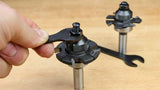 Hand tightening a carbide slot cutter router bit with a wrench on a workbench
