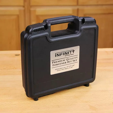 Black plastic carrying case labeled Premium Quality Forstner Bit Set on a wooden workbench.