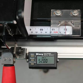 Digital readout measuring tool displaying 52.00 on precision woodworking fence rail.
