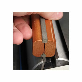 Hand holding jointer knife setting jig with wood grip on metal jointer cutterhead