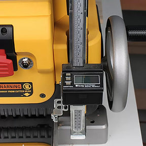 Close-up of a woodworking planer with electronic digital height gauge and precision adjustment wheel.