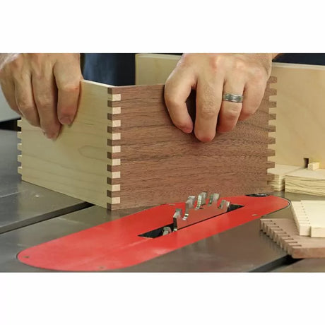 Woodworker assembling a dovetail joint box on a table saw with dado blade set